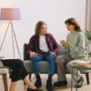 Couple talking with a therapist during a couples therapy session in a bright office