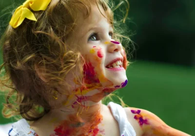 Child engaged in art therapy session painting at a table in a therapy room