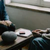 A counselor provides support for an autistic individual during a therapy session.