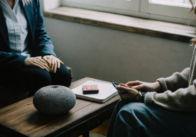 A counselor provides support for an autistic individual during a therapy session.